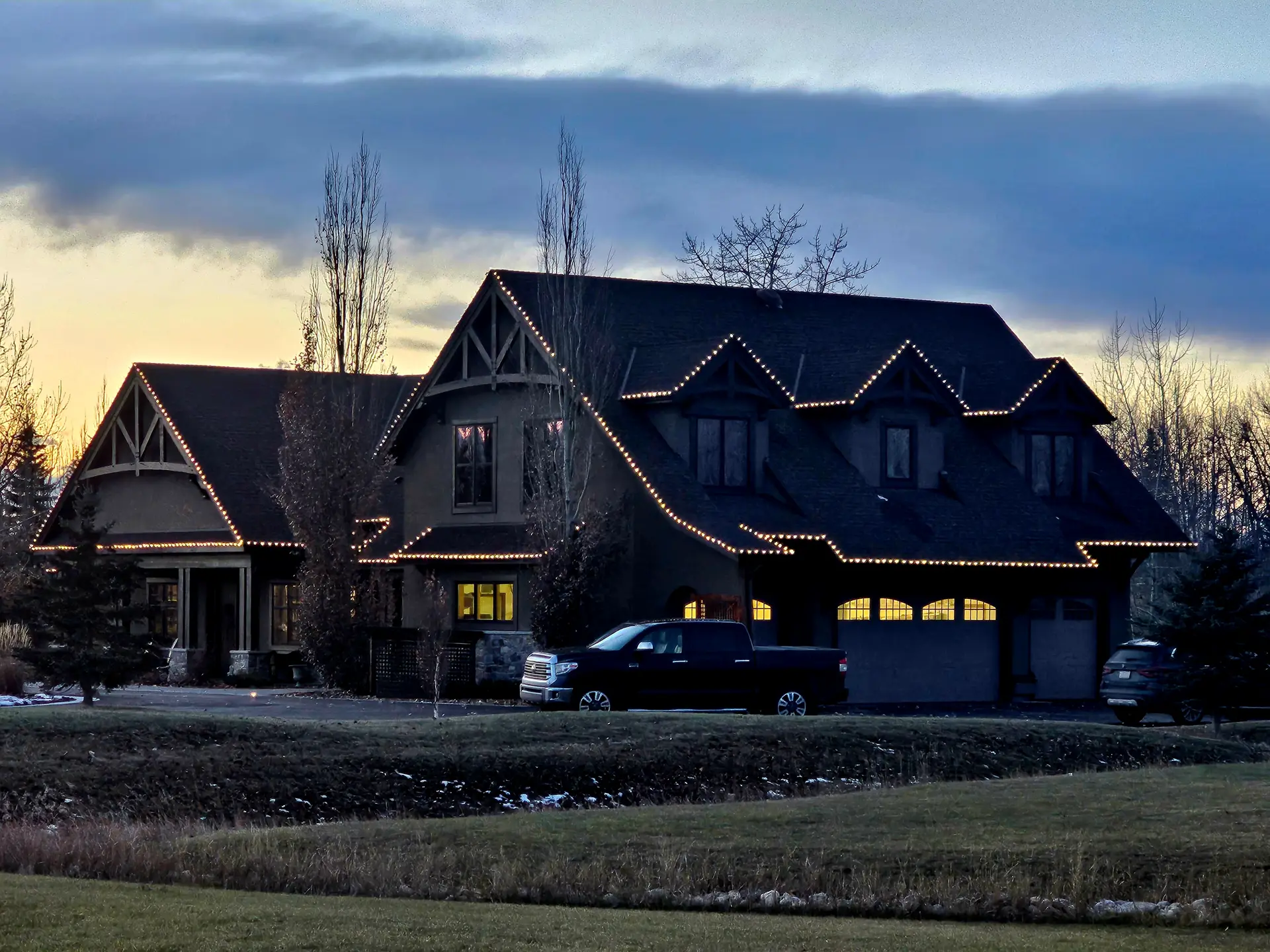 Home at dusk with a subtle warm white roofline, under a blue-hour sky